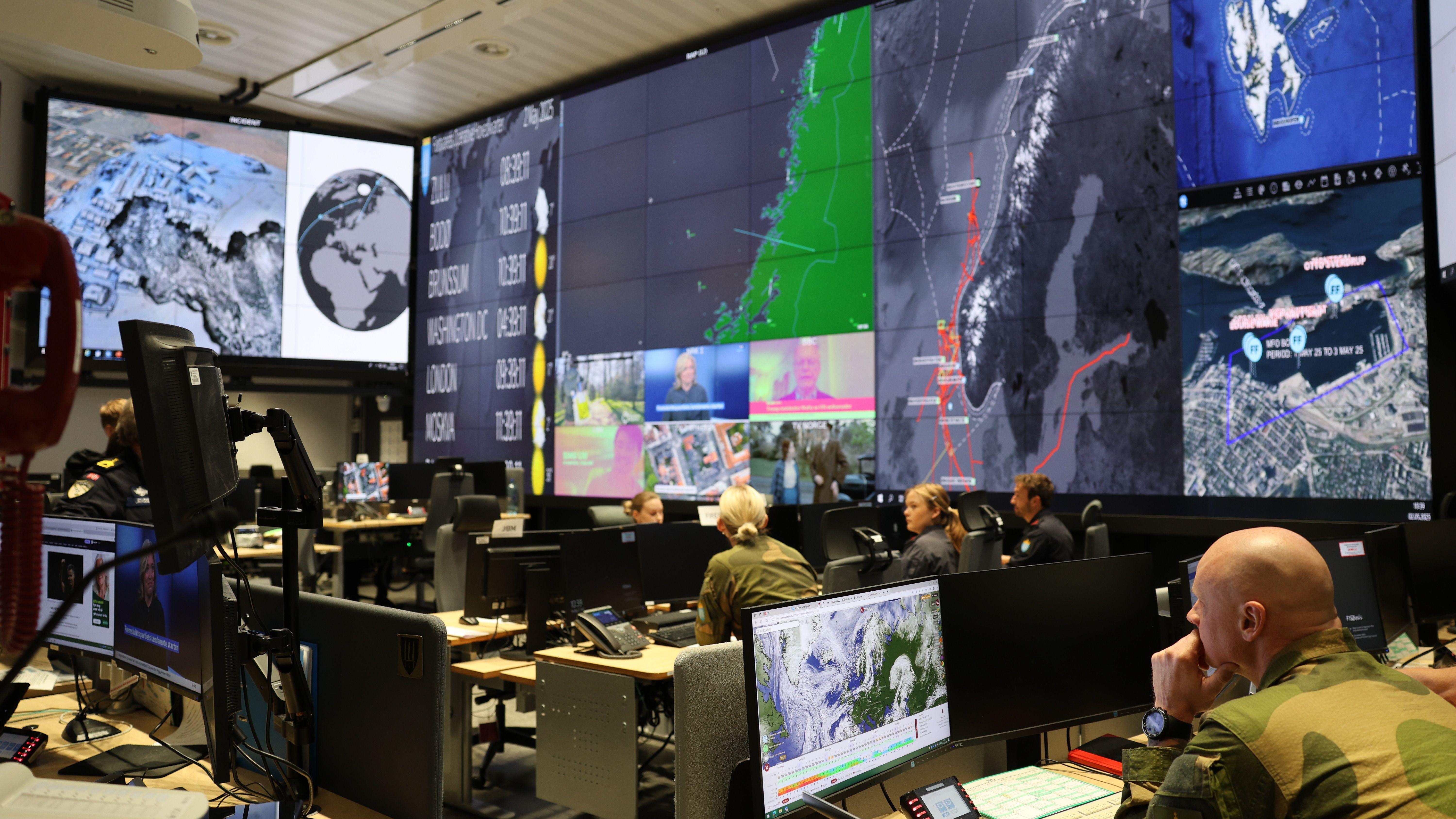 Varios militares en una sala con pantallas gigantes que muestran el mapa de Noruega.