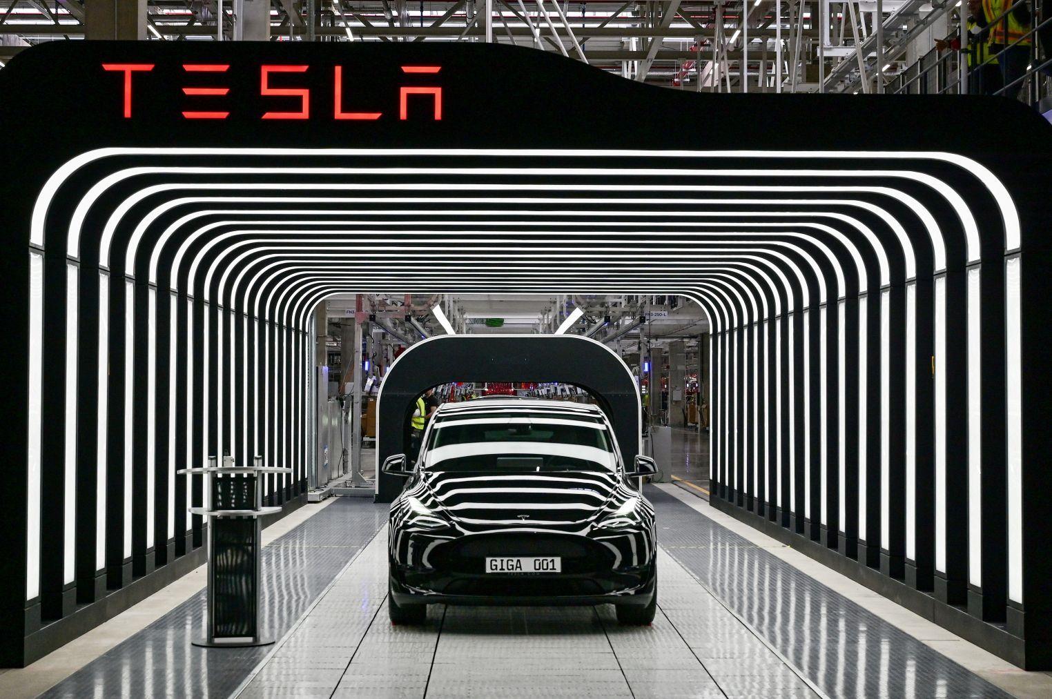 Logotipo da Tesla e carro cercado por luzes