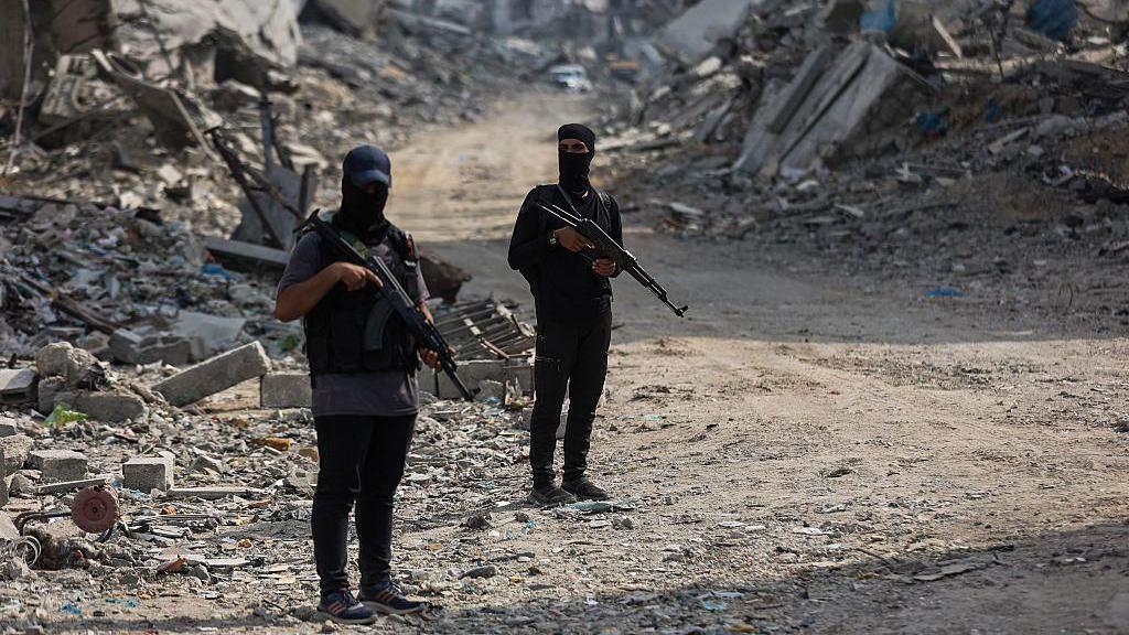 Combatientes de Hamás armados en una calle con escombros
