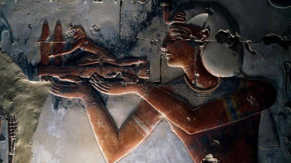 رسم للملك سيتي الأول في معبد أبيدوس يظهر نصف جسده ويحمل هدية مجسم صغير رجل برأس أسد