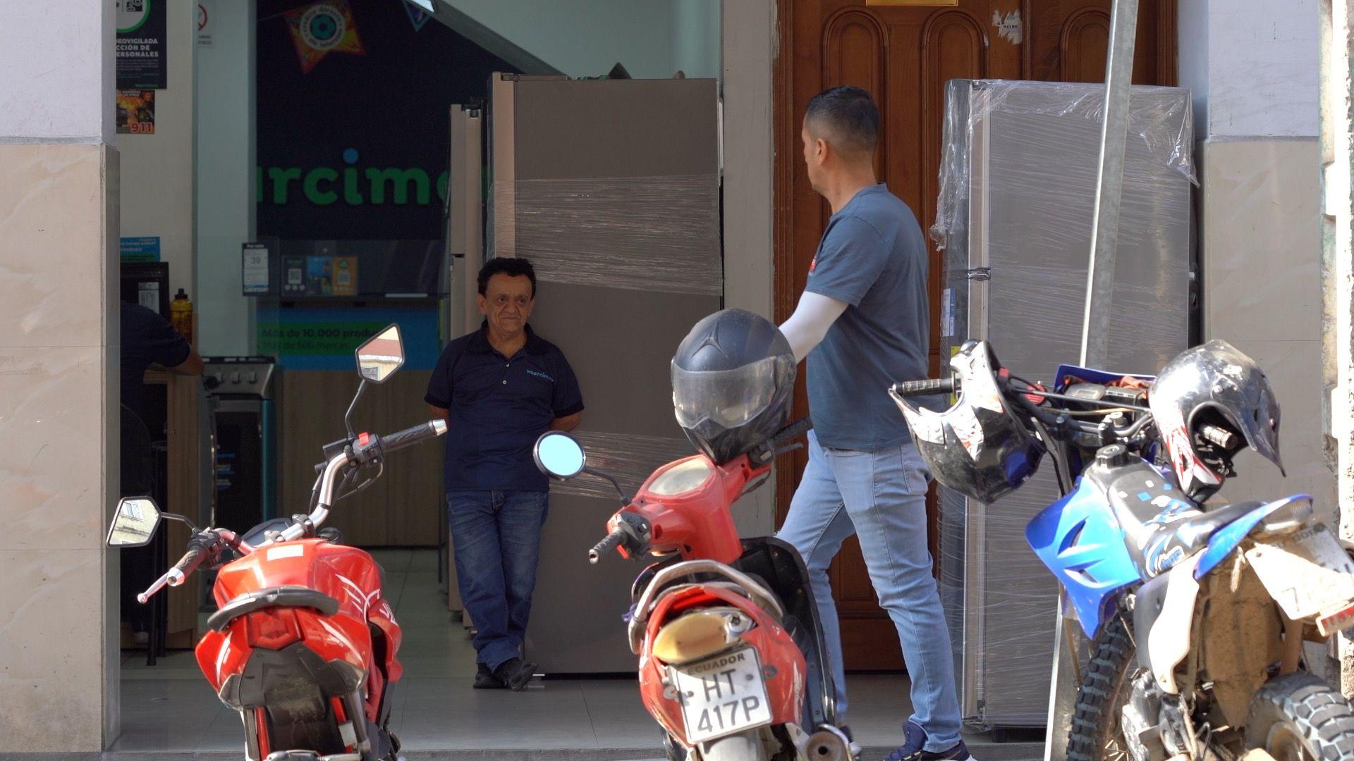 Persona de talla baja en la entrada de un almacén.