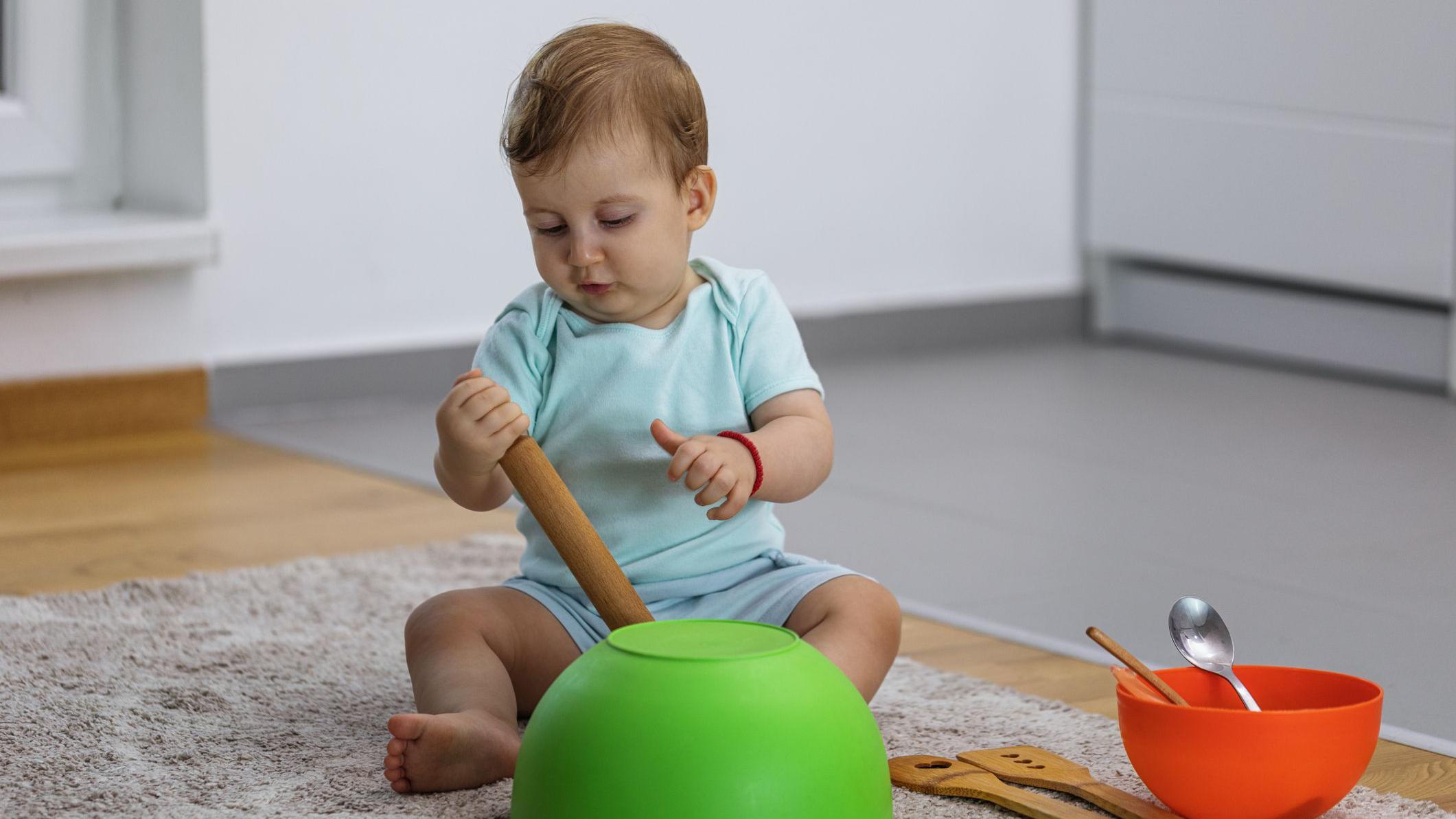 Bebé jugando con objetos sobre una alfombra