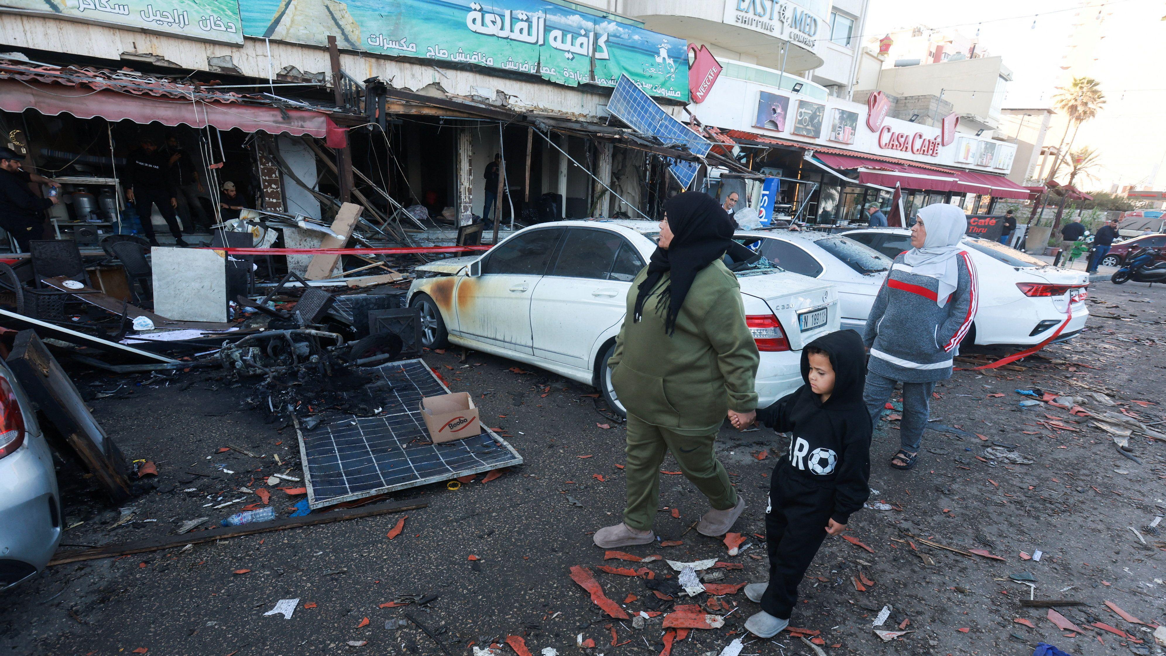 黎巴嫩西頓某咖啡店外兩名女士拖著小孩走過以軍空襲破壞現場（8/4/2026）