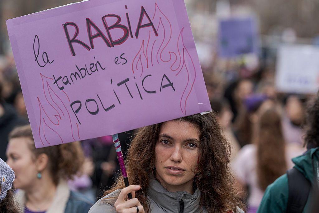 Una mujer porta un cartel que dice "la rabia también es política". 