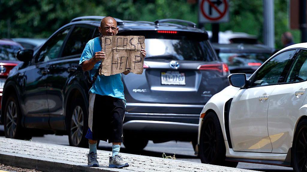 Una persona pide ayuda a lo largo del Rock Creek Parkway el 25 de julio de 2025 en Washington, DC. El presidente Donald Trump firmó una orden ejecutiva que facilita a las ciudades y estados la eliminación de personas sin hogar de las calles. (Foto de Kevin Dietsch/Getty Images)