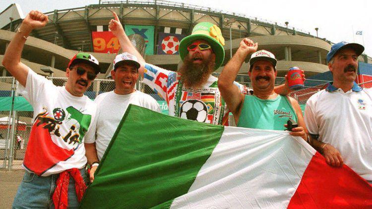 Torcedores italianos aguardam a chegada da sua sele&ccedil;&atilde;o ao est&aacute;dio, durante a Copa do Mundo de 1994, gritando e mostrando a bandeira do seu pa&iacute;s