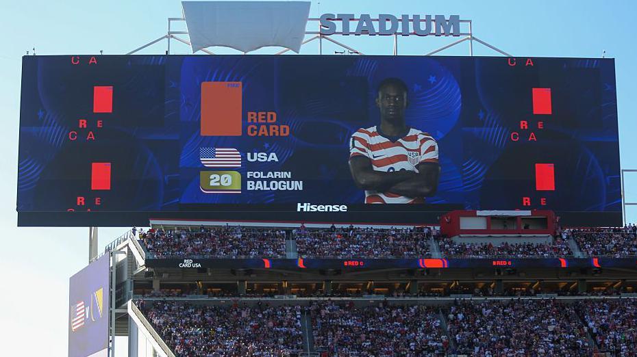 Skandal na Mundijalu: Kakva je uloga Trampa u poništavanju crvenog kartona fudbaleru SAD 3 pogled na veliki ekran na stadionu, na njemu je lik fudbalera Balogana