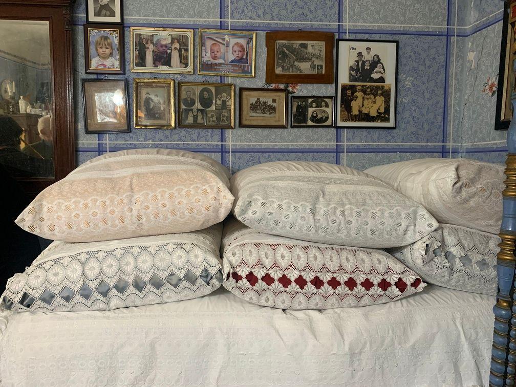 Šareni jastuci naređani na krevetu u sobi koja je okrečena u plavo