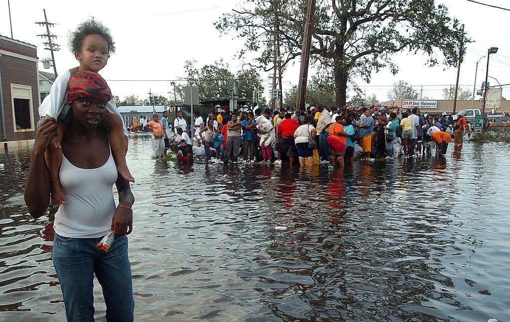 Un grupo de sobrevivientes caminando en una calle inundada.
