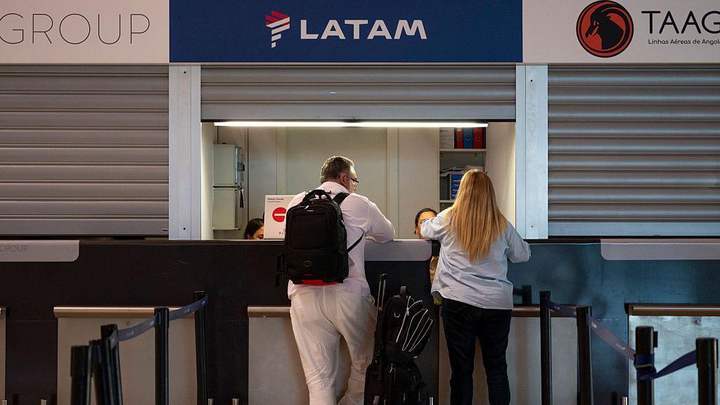 Dos pasajeros en el mostrador de Latam del aeropuerto de Barajas
