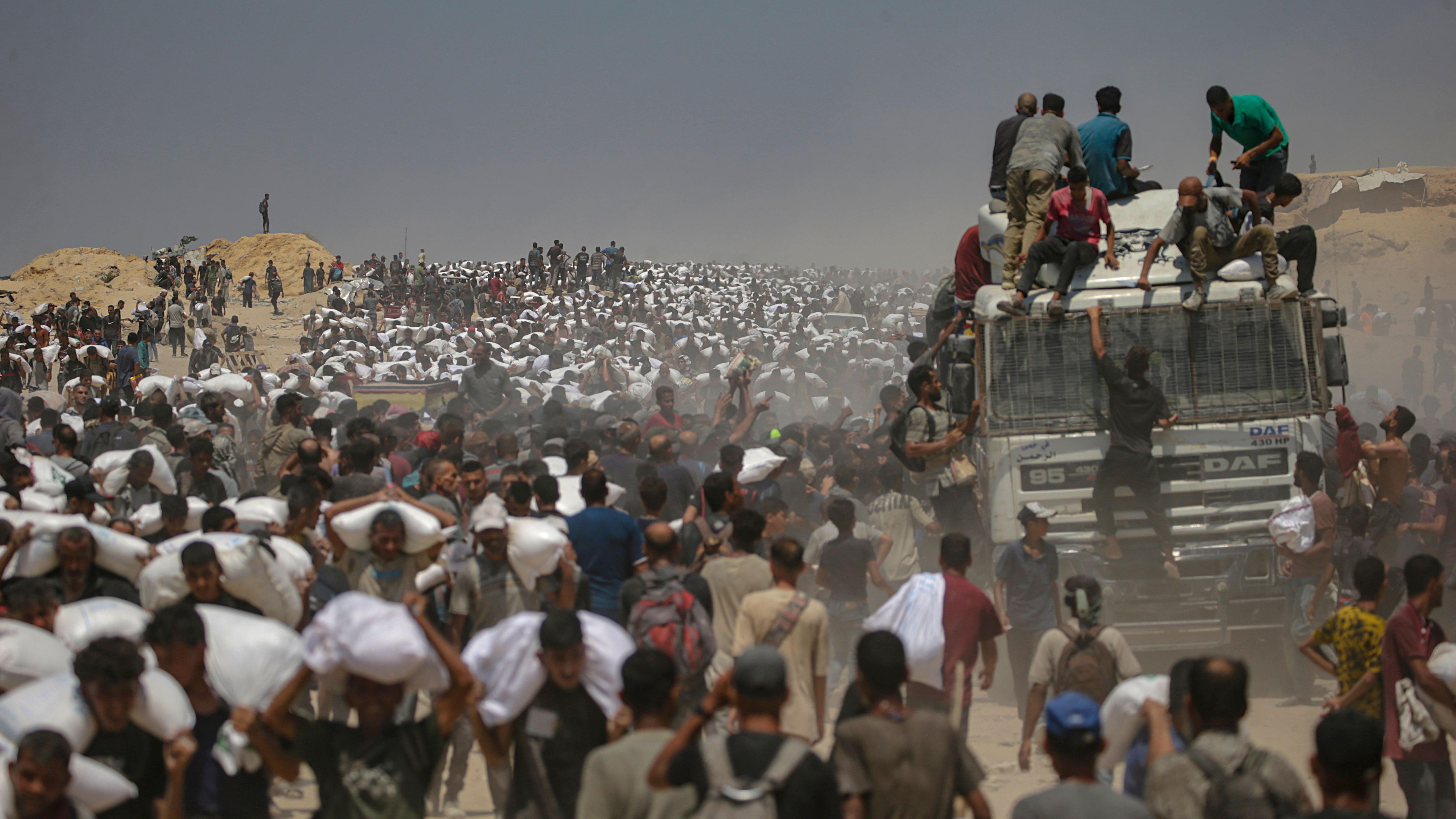 Caminhão de ajuda humanitária distribui alimentos para uma imensa quantidade de pessoas na Faixa de Gaza