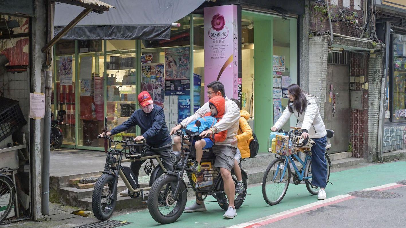 台北街頭一個家庭騎腳踏車車