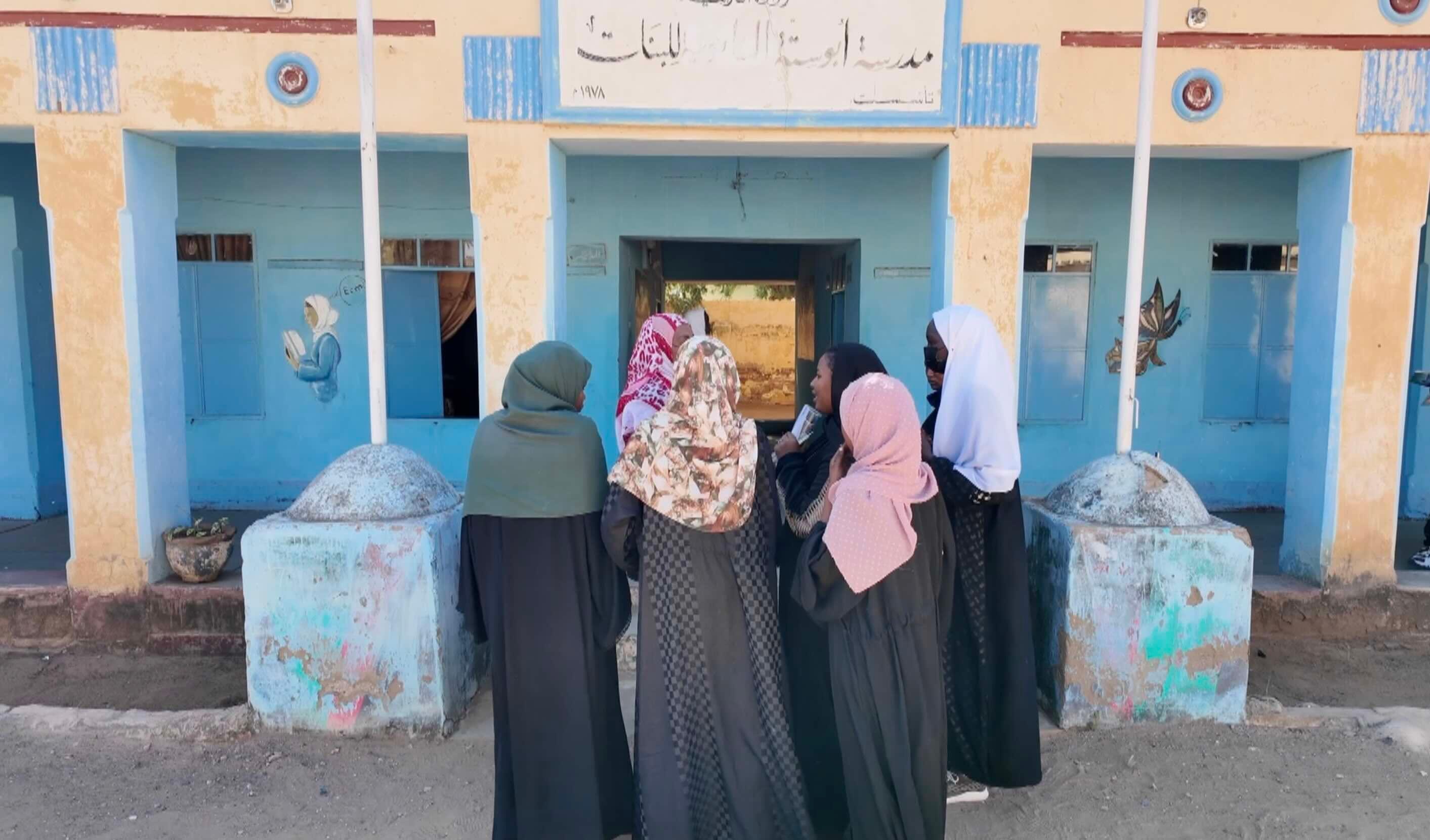 طالبات أمام مدرسة أبو ستة التي تعرضت للقصف.