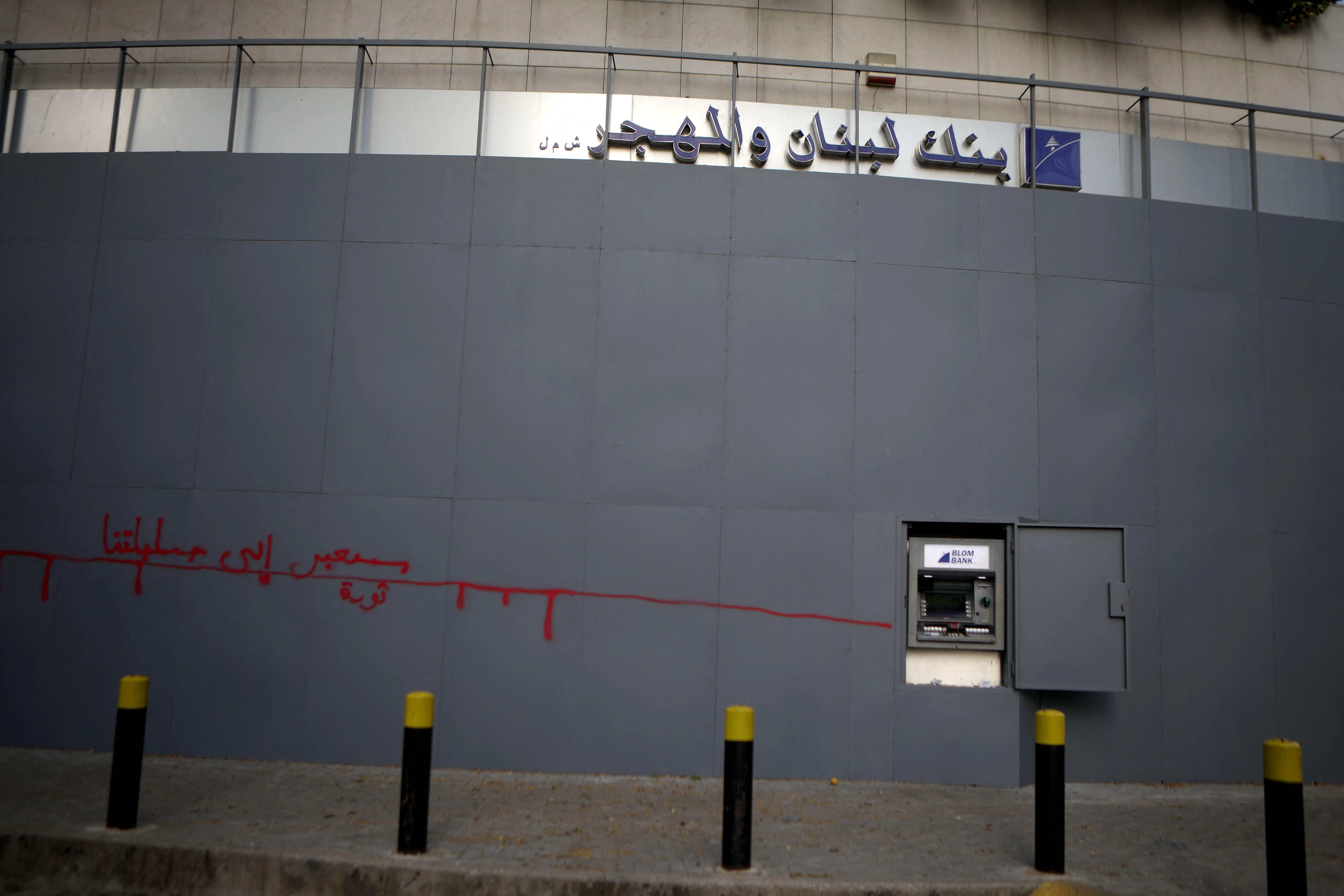 مدخل محصّن لفرع مصرف "لبنان والمهجر" في بيروت، تظهر عليه كتابات غرافيتي وفتحة صراف آلي مفتوحة أمام الزبائن، في صورة التُقطت عام 2020 خلال ذروة الأزمة المالية في لبنان.