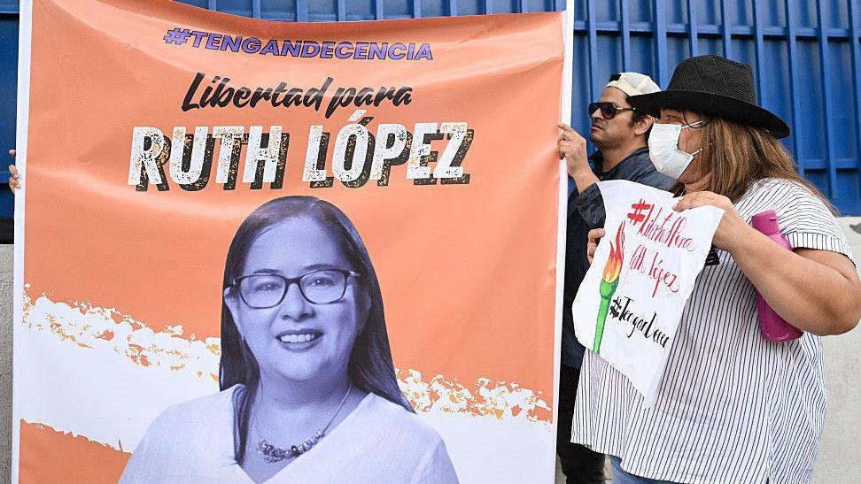 Manifestantes penduram cartaz pedindo a libertação da ativista Ruth López