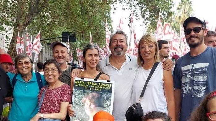 Personas posan a la cámara con la foto de una mujer desaparecida en la última dictadura argentina