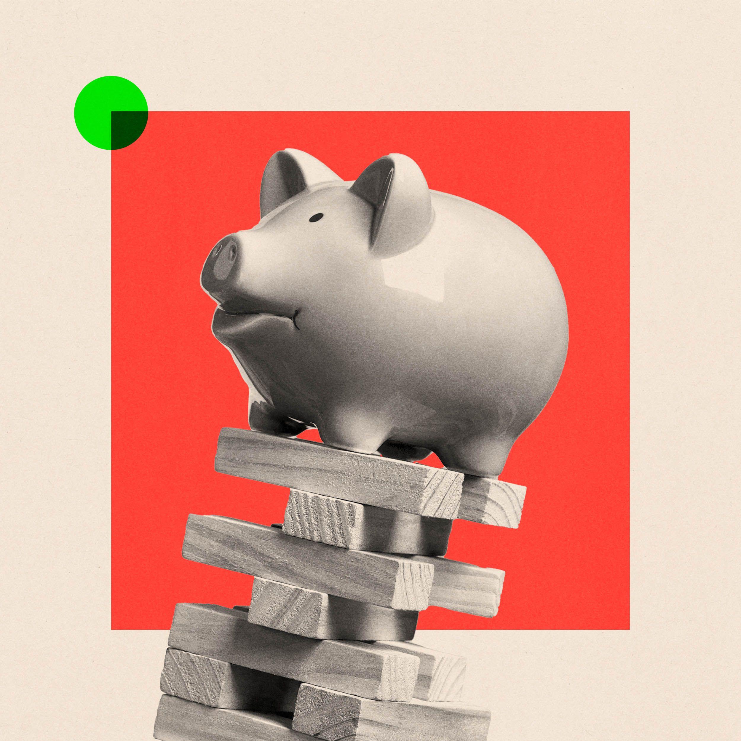 흔들리는 나무 블록 위에 위태롭게 놓여 있는 돼지 저금통