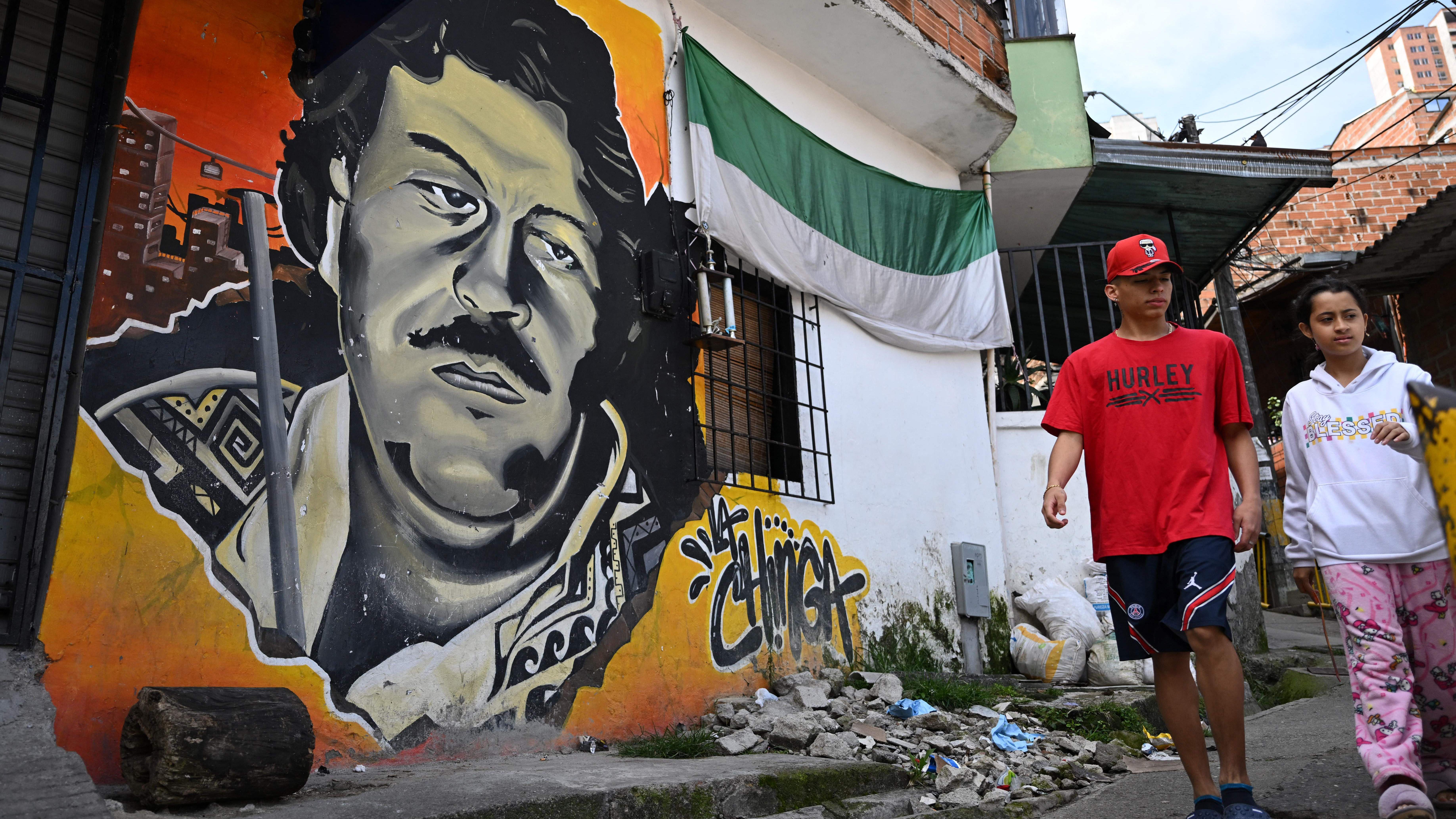 Niños caminando junto a un mural de Pablo Escobar en Medellín en 2023.