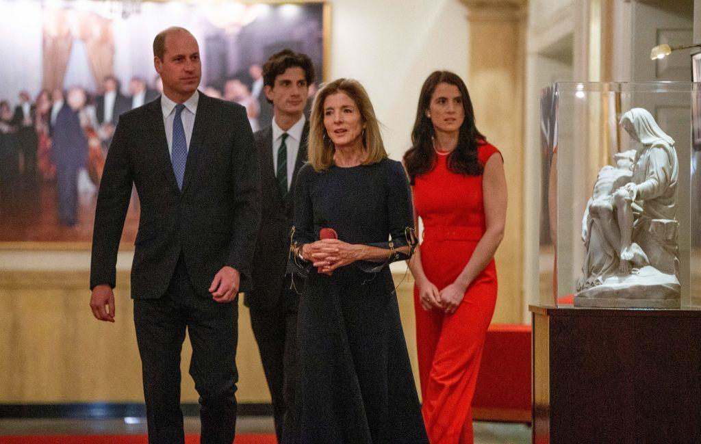 El príncipe William camina por un salón con obras de arte, acompañado de Caroline Kennedy y Tatiana y Jack Schlossberg.