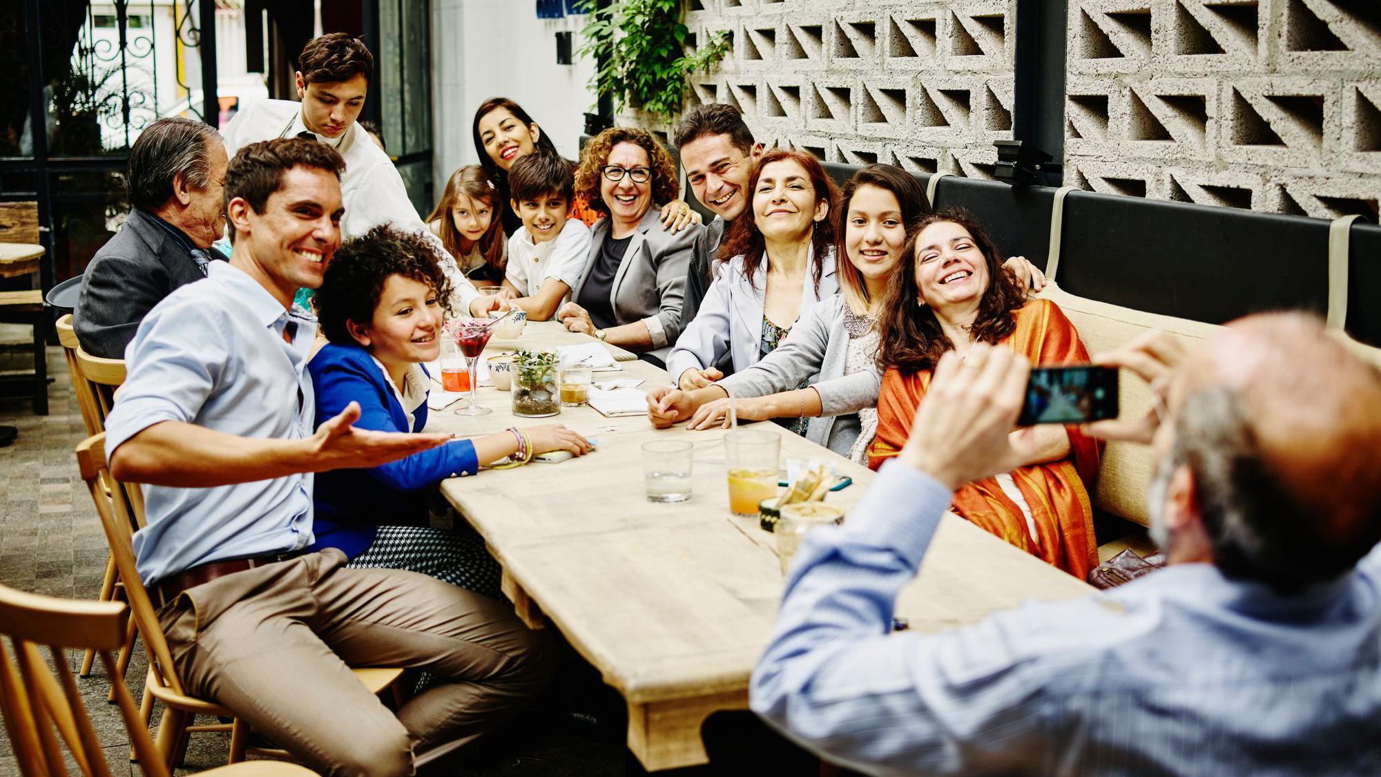 Una familia posa para una foto grupal alrededor de una mesa