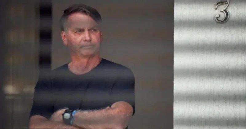 Jair Bolsonaro de camisa preta e braços cruzados atrás de grades, em foto de arquivo anterior a sua prisão na Superintendência da Polícia Federal