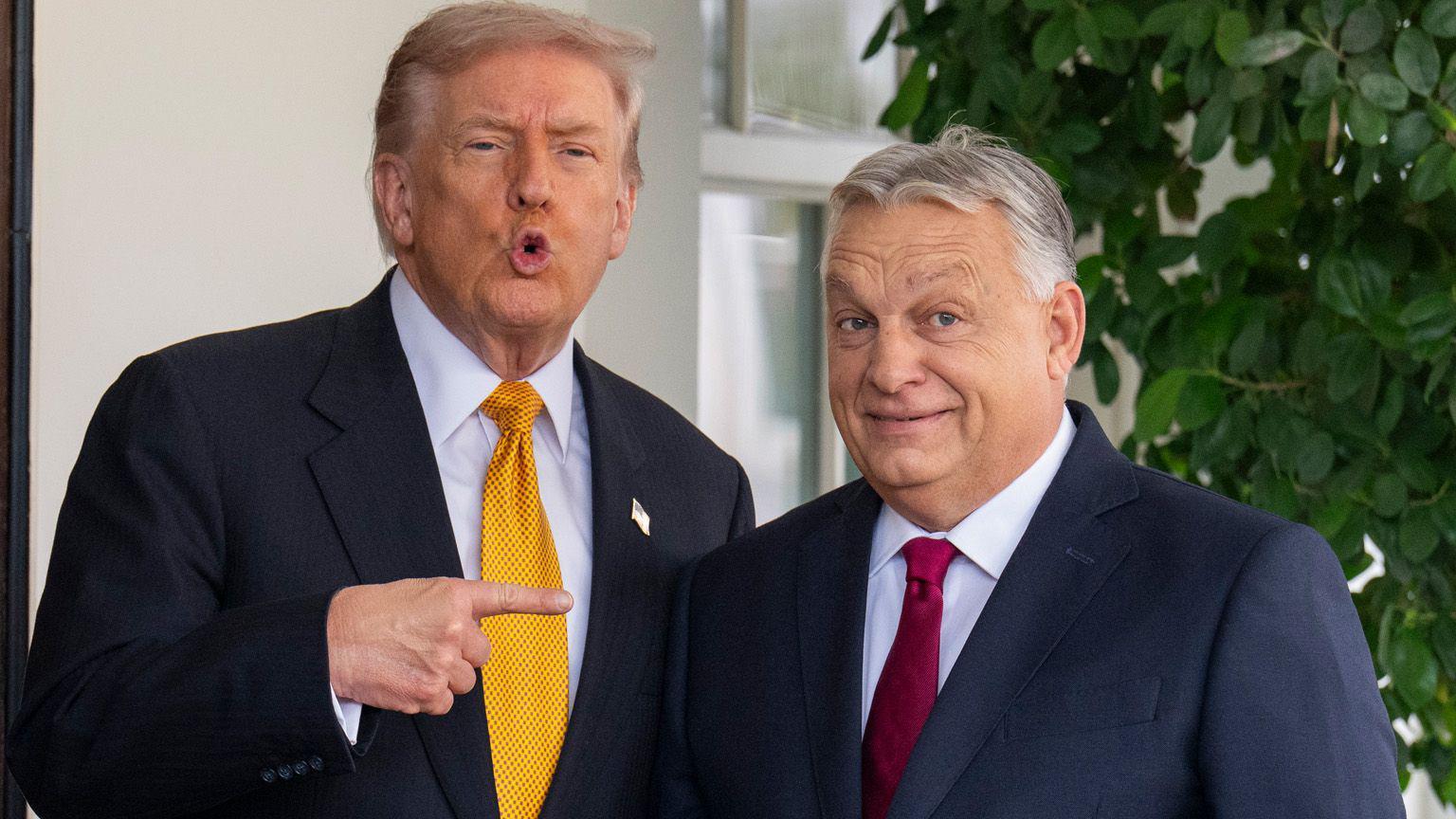 Donald Trump veste um terno azul-escuro e uma gravata amarela enquanto aponta para Viktor Orb&aacute;n, que est&aacute; sorrindo. Orb&aacute;n veste um terno azul-escuro e uma gravata vermelha.