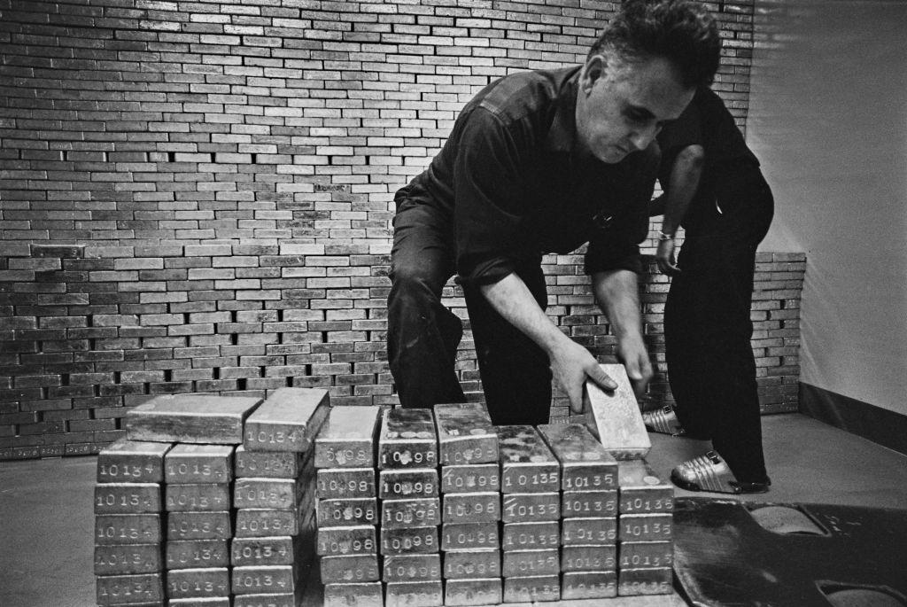 Dos empleados colocan lingotes de oro en pilas en el sótano de la Reserva Federal en una imagen de archivo. 