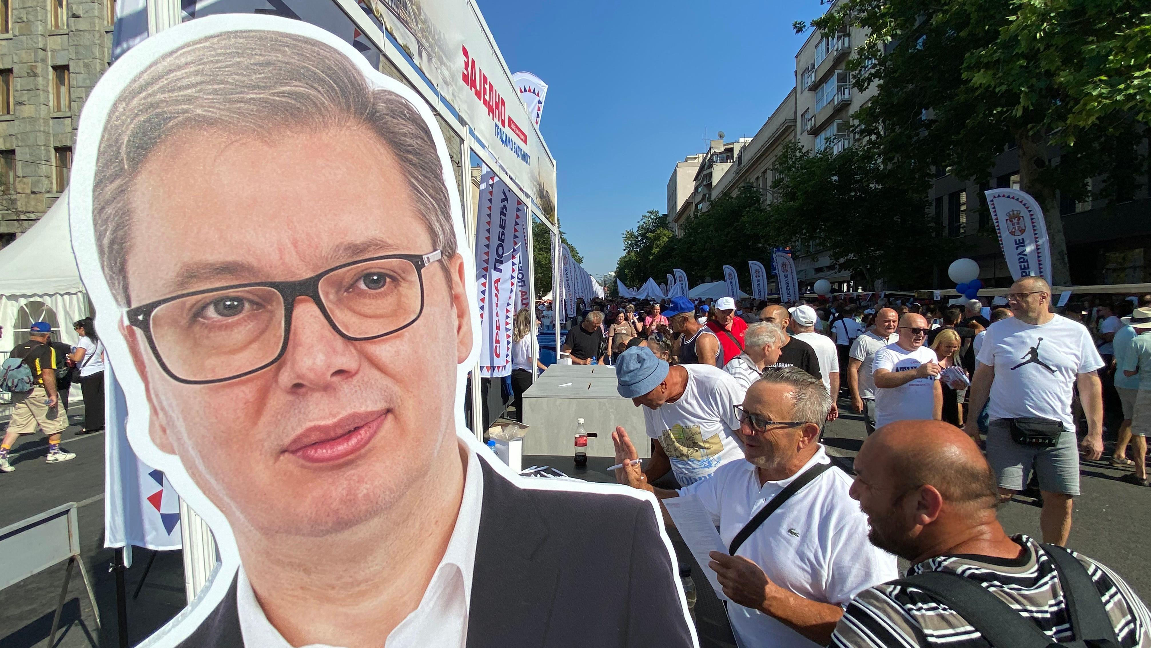 Vucic na kartonu, okolo ljudi