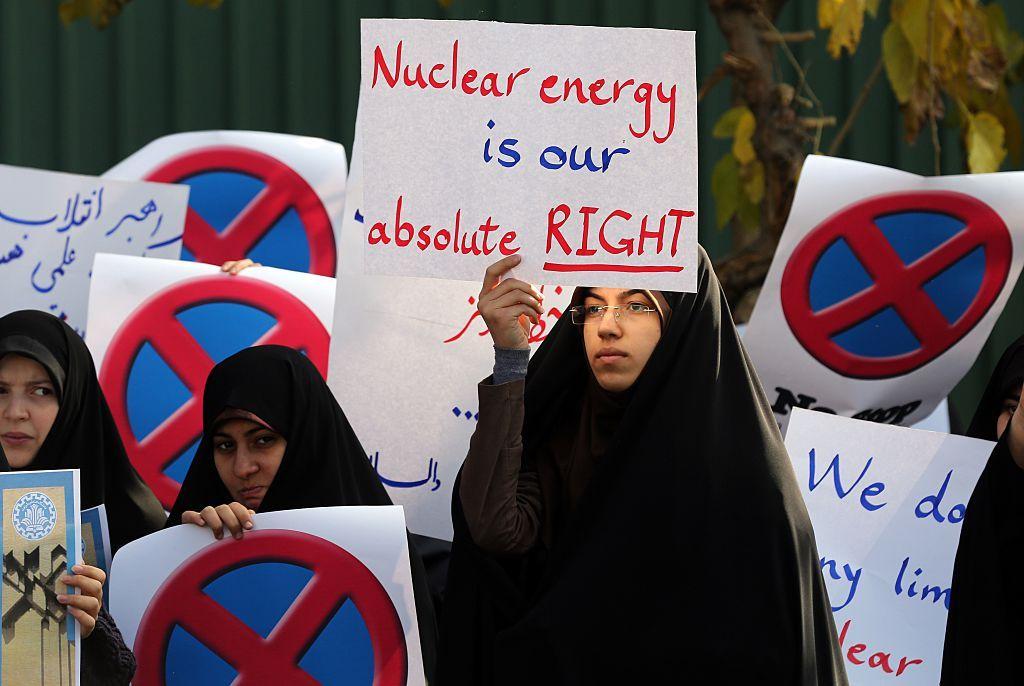 Una estudiante iraní sostiene un cartel que dice "La energía nuclear es nuestro absoluto derecho" durante una manifestación frente al reactor de investigación de Teherán el 23 de noviembre de 2014, para mostrar su apoyo al programa nuclear de Irán.