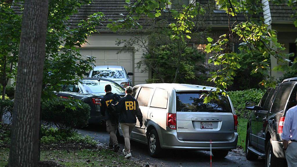 Pessoas com uniforme do FBI entrando em uma casa