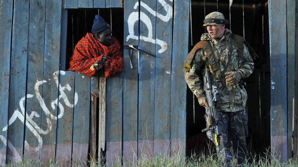 Un soldado y un hombre keniano, contratado para interpretar el papel de un insurgente, participan en un ejercicio militar simulado de la Unidad de Entrenamiento del Ejército Británico en Kenia (BATUK), junto con las Fuerzas de Defensa de Kenia (KDF), en el rancho Ol-Daiga, situado en lo alto de la meseta de Laikipia, en Kenia, el 27 de marzo de 2018.