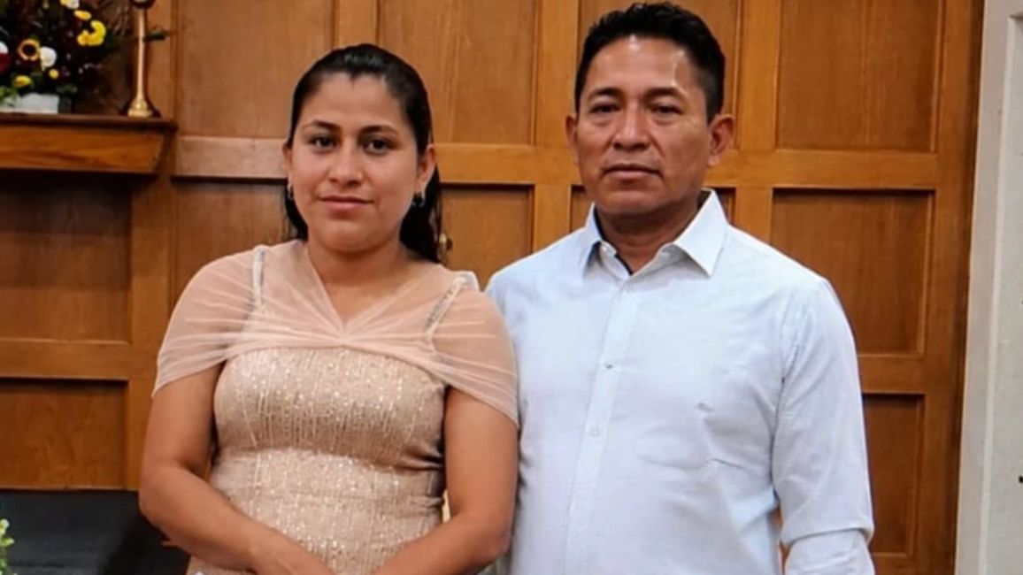 Glendy González de la Cruz y Nixon Pérez Paz posan juntos, sonrientes, frente a un altar en una iglesia.