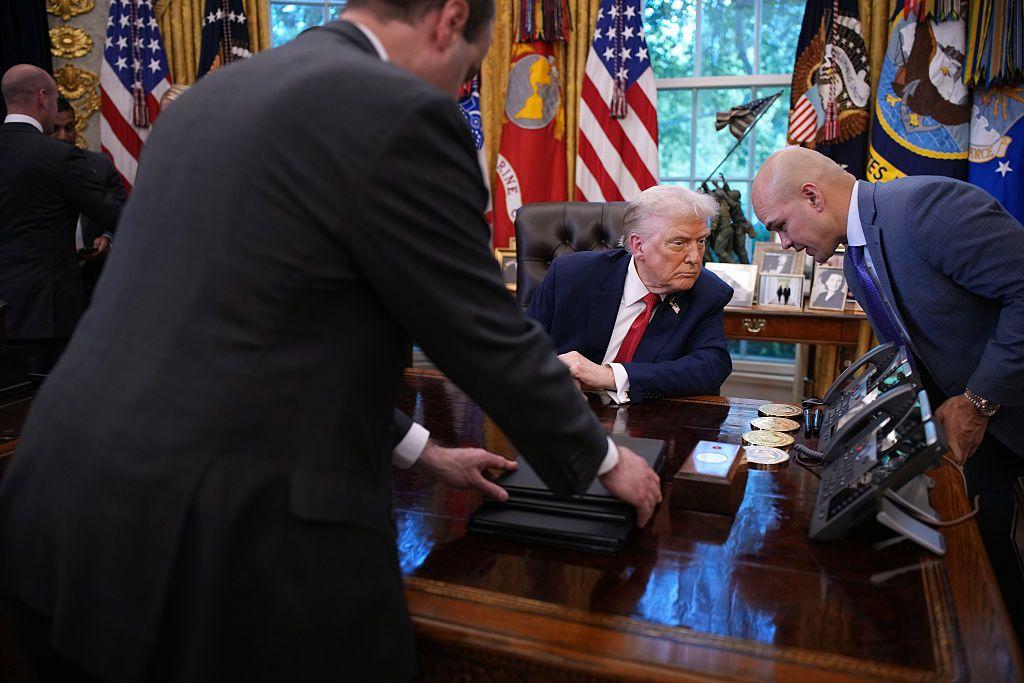 El presidente de EEUU Donald Trump habla con uno de sus asesores en un agitado momento en el salón oval