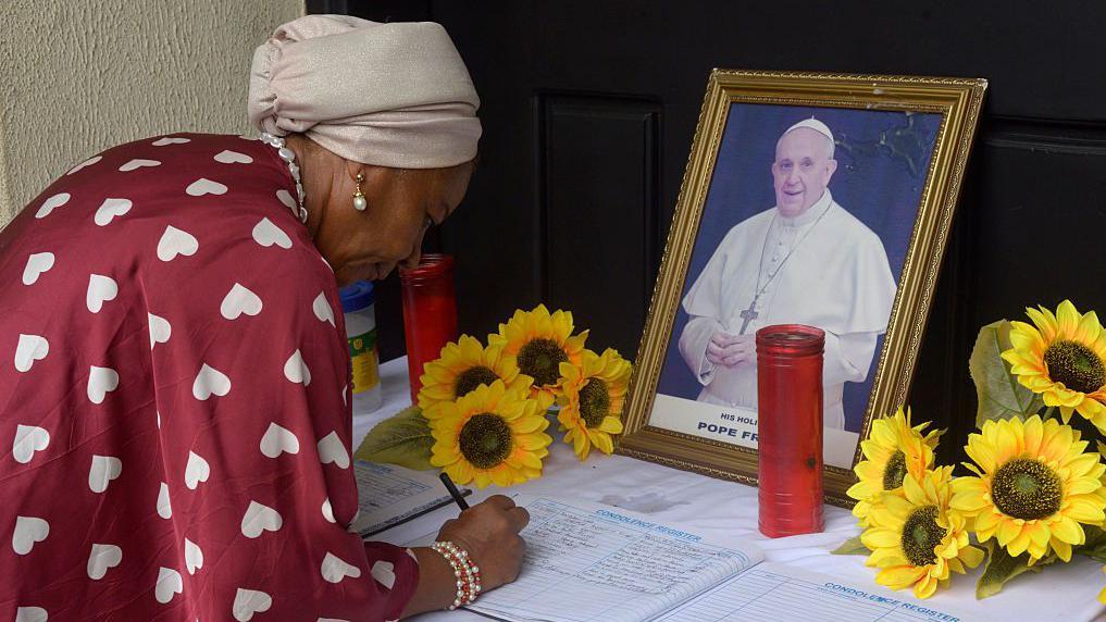 Una mujer católica rinde tributo al papa Francisco.