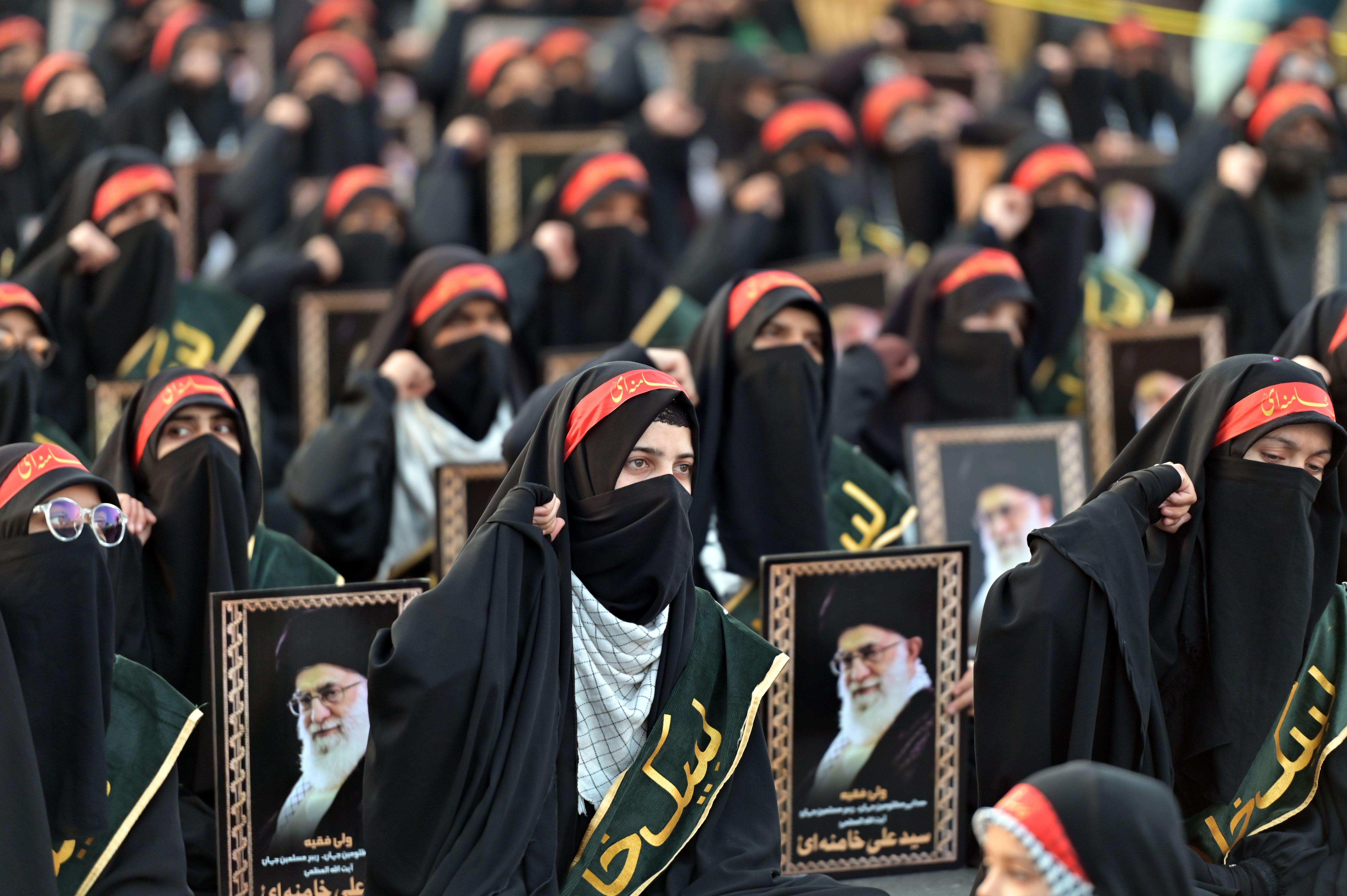 žene drže postere sa likom vrhovnog vođe irana, ajatolaha Alija Hamneija