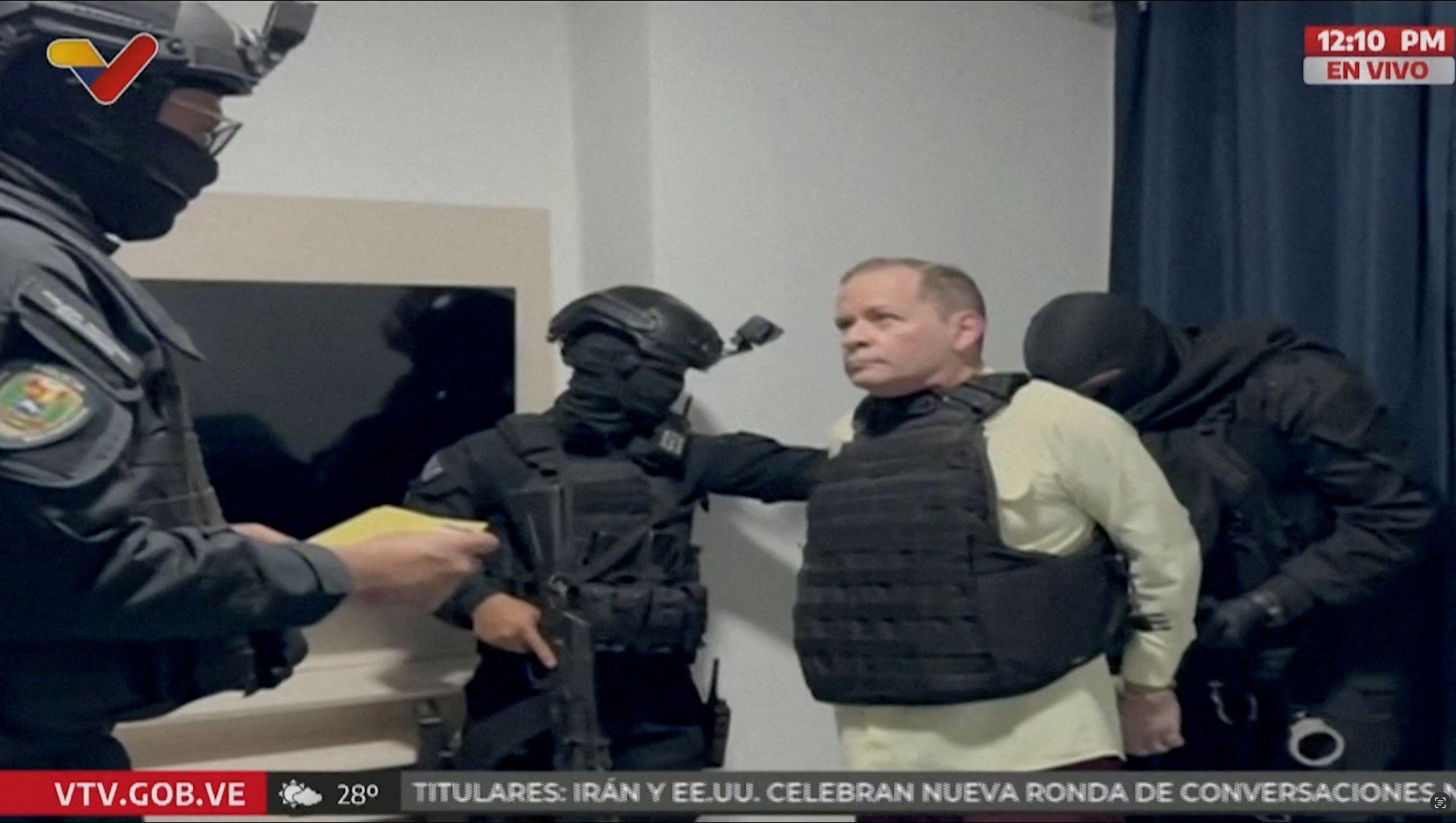 El político opositor venezolano Juan Pablo Guanipa, vestido con un chaleco antibalas, observa cómo lo esposan tras ser detenido por agentes de las fuerzas del orden venezolanas, en un lugar desconocido, en esta captura de pantalla de un vídeo difundido el 23 de mayo de 2025