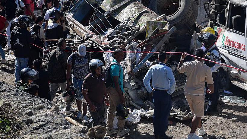 Varios rescatistas y transeuntes están alrededor de los escombros que quedaron del atentado con explosivos en Colombia.