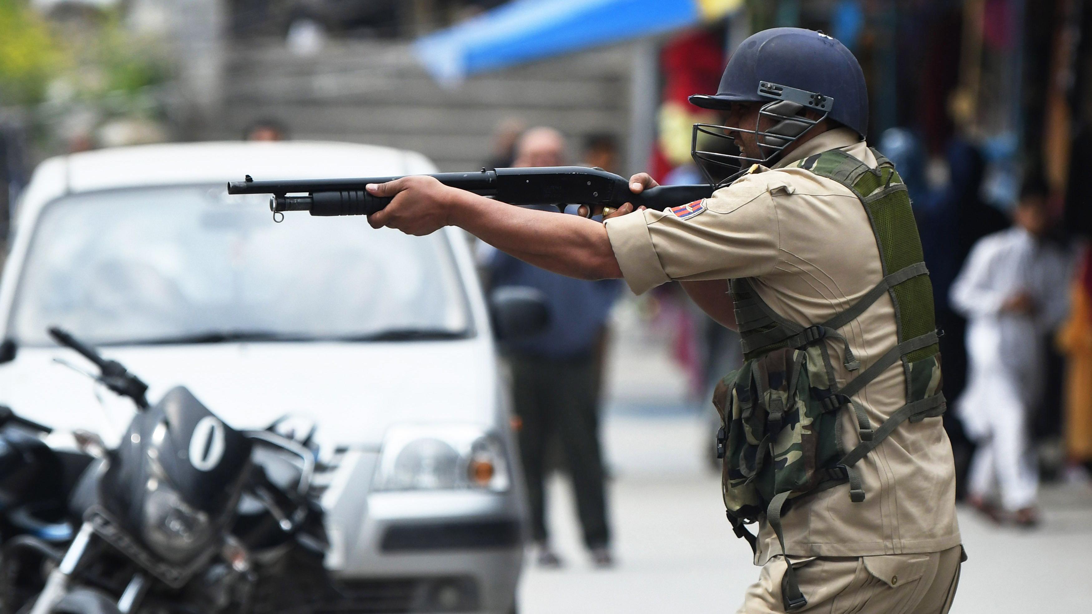 مئی 2019 میں جمعے کے روز سری نگر کی جامع مسجد کے باہر جھڑپ کے دوران ایک پولیس اہلکار مظاہرین کی جانب پیلٹ گن تان رہا ہے (فائل فوٹو)