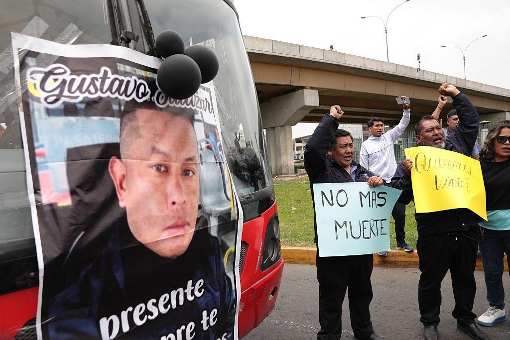 Los conductores de autobús sostienen carteles mientras bloquean la plaza Habich durante una protesta convocada por las empresas de transporte público contra la extorsión y exigiendo más seguridad.