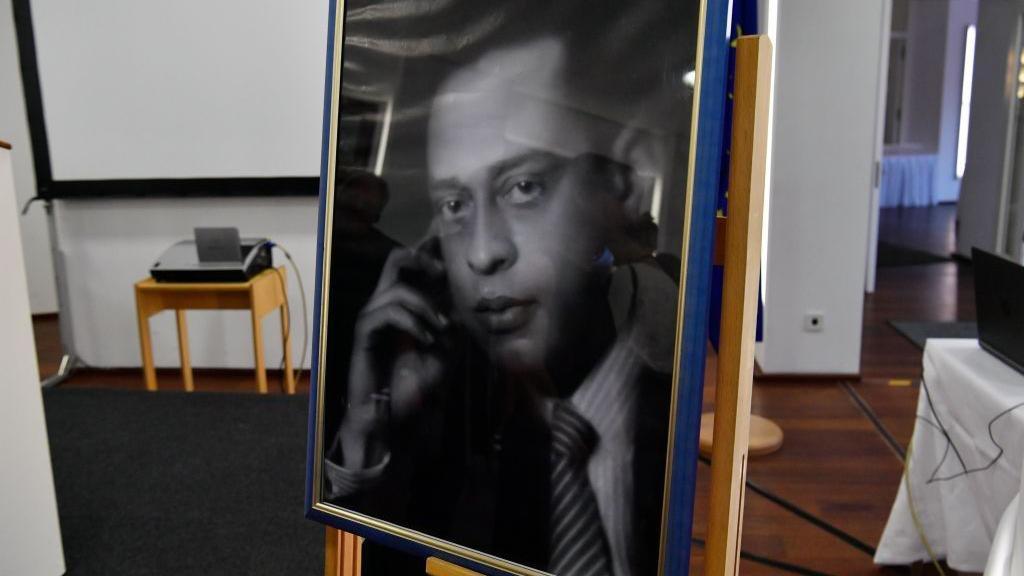 Um retrato em preto e branco emoldurado mostra o m&eacute;dico eg&iacute;pcio Mohamed Helmy usando camisa listrada e gravata