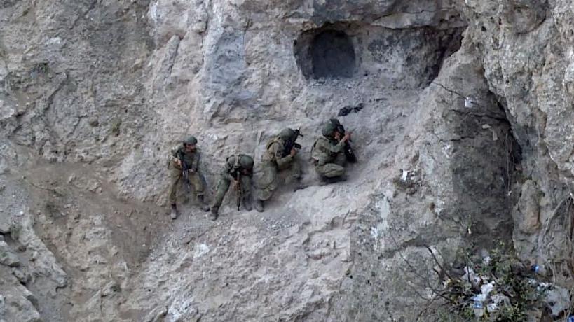 جنود أتراك عند مدخل كهف في زاب، في صورة يبدو أنها التقطت نهاراً. يظهر في الصورة 4 جنود يرتدون الزي العسكري ويحملون أسلحة.