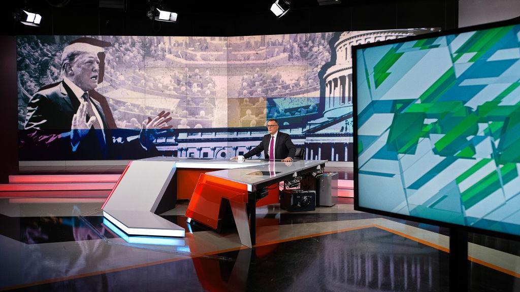 O âncora Kevin Owen apresenta uma reportagem sobre o impeachment do presidente americano Donald Trump em um programa da RT