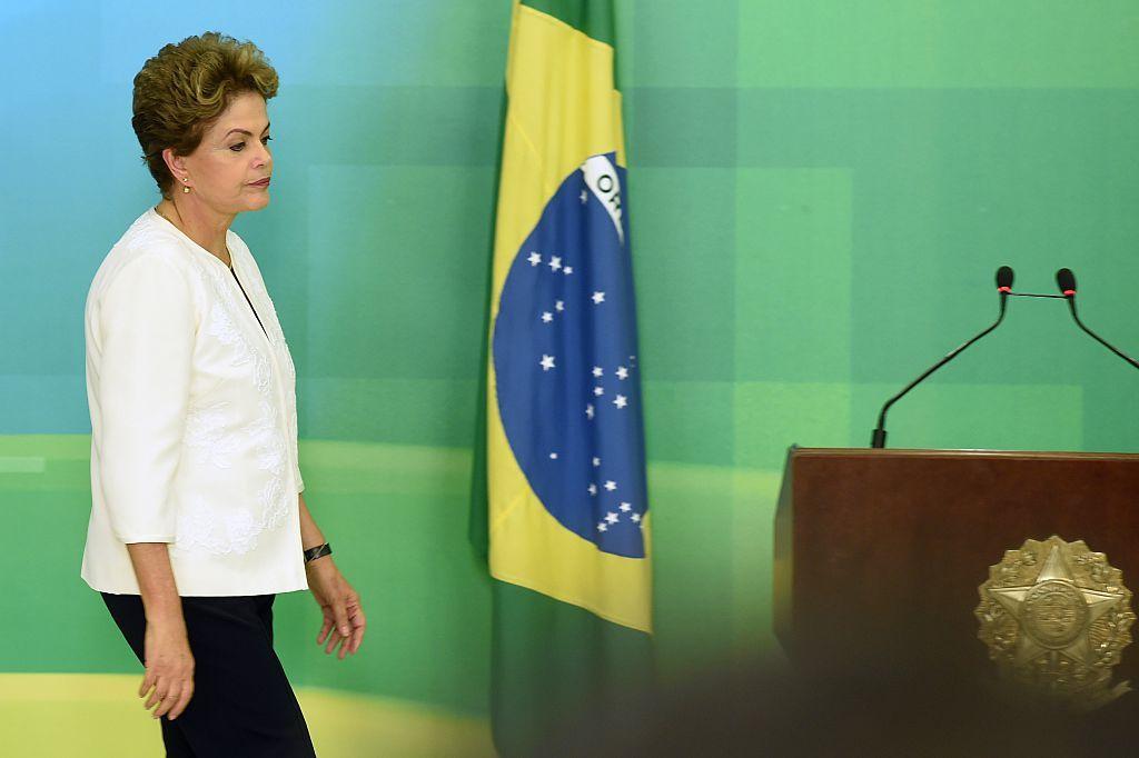 Dilma ao lado de uma bandeira do Brasil