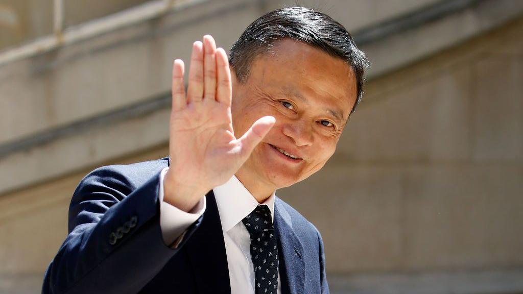 Jack Ma, de terno, acenando