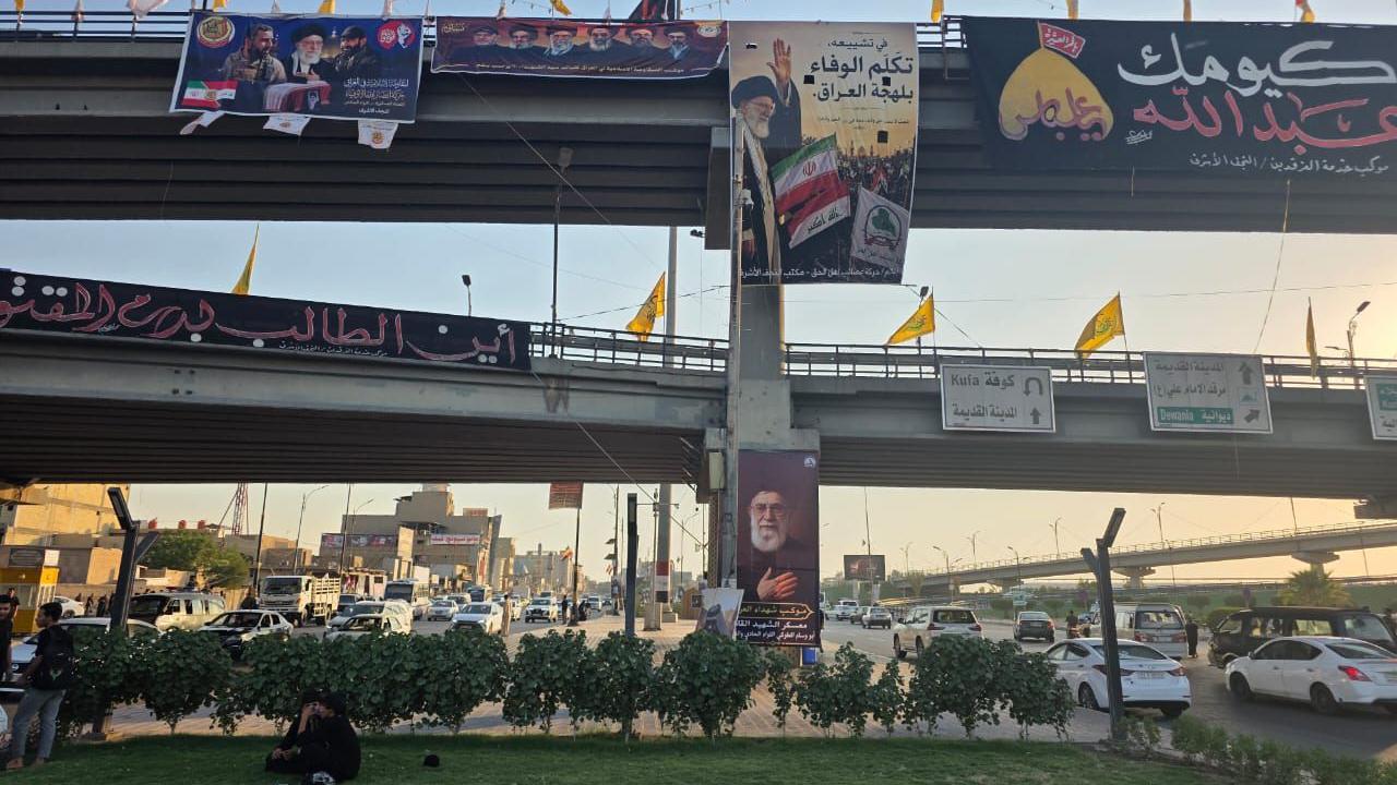 جسر في مدينة النجف علقت عليه رايات صفراء وصورة علي خامنئي وصور قادة عسكريين وعلماء دين شيعة