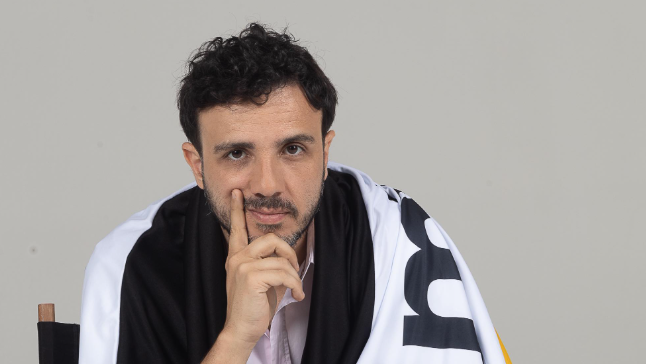 Renan Santos enrolado em uma bandeira