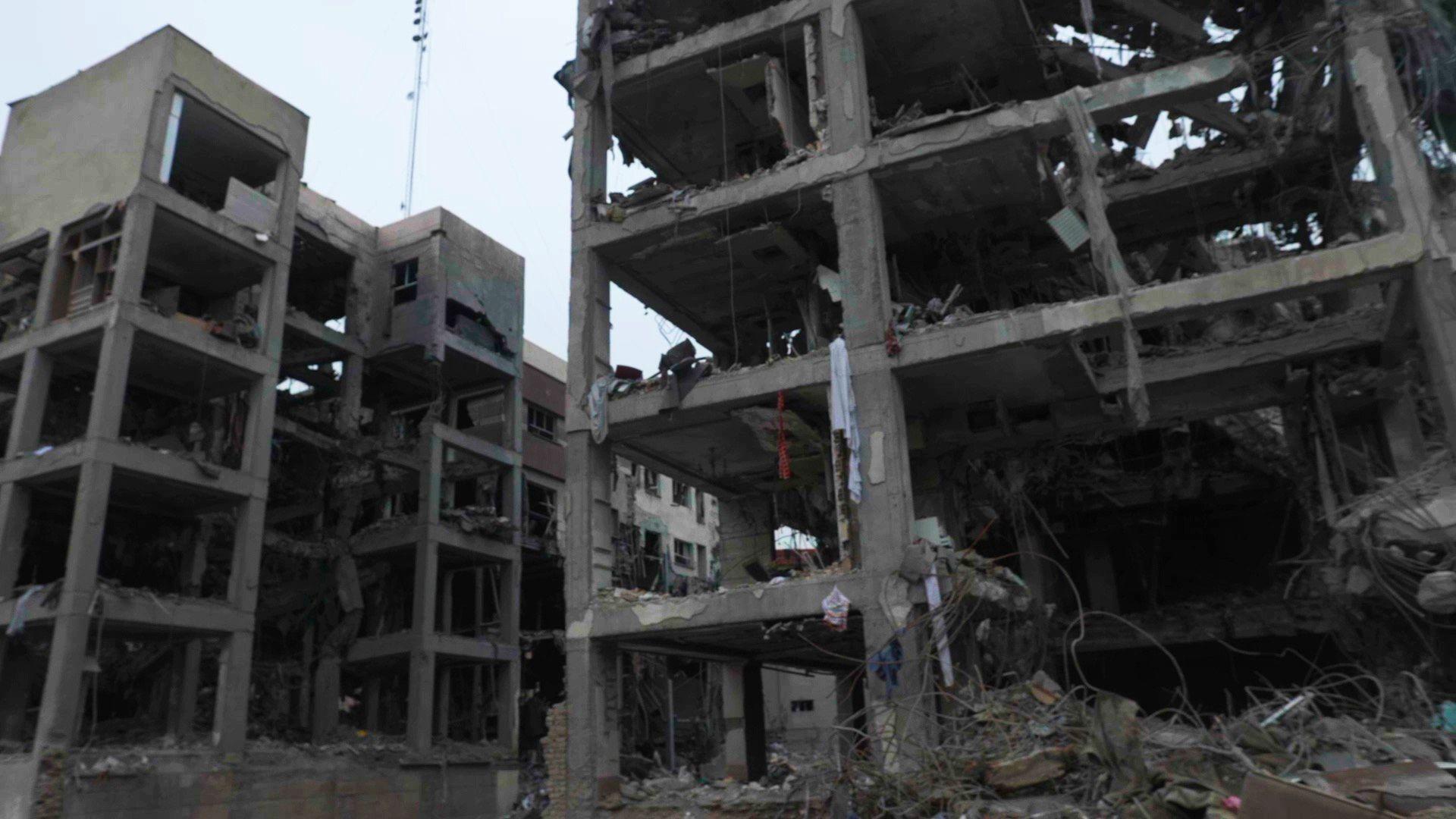 Dois pr&eacute;dios destru&iacute;dos, com quatro ou cinco andares, com janelas e paredes estouradas. Algumas colunas e lajes de concreto ainda permanecem. H&aacute; alguns peda&ccedil;os de tecido pendurados na estrutura e alguns metais retorcidos no ch&atilde;o.