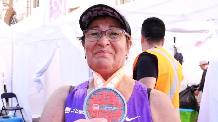 Elisabeth Osorio mostrando la medalla que ganó al terminar la maratón.