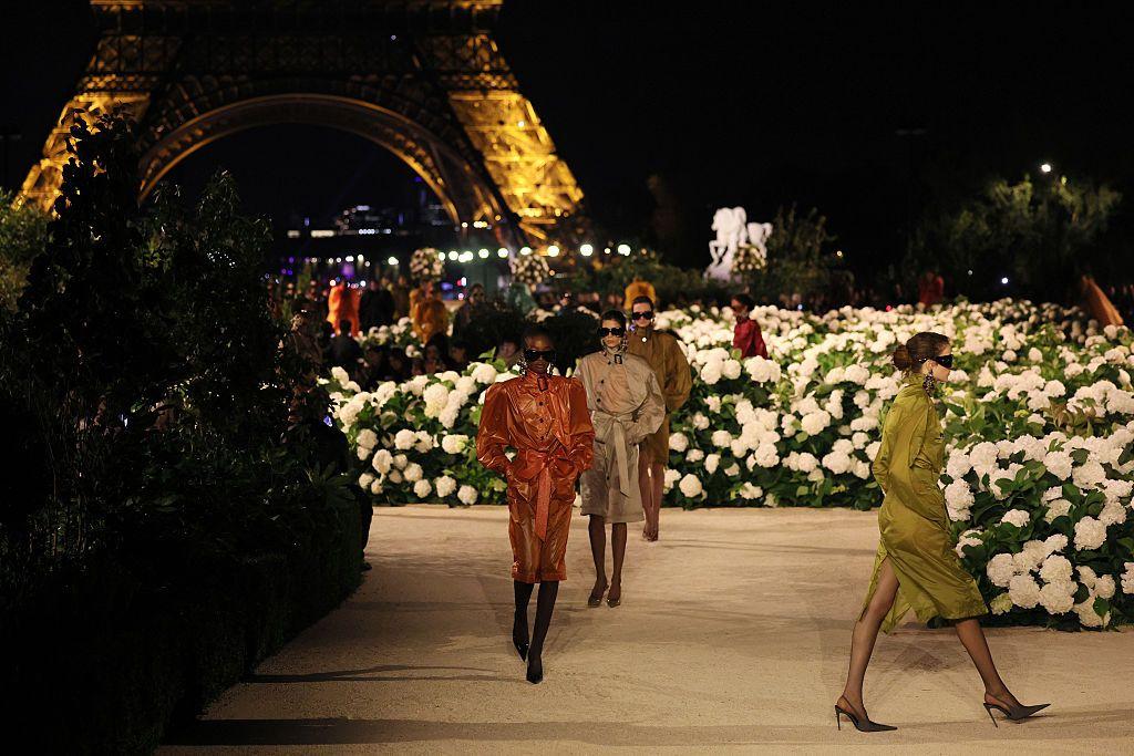Modelo desfilan durante el desfile de Primavera/Verano 2026 de Moda Femenina de Saint Laurent como parte de la Semana de la Moda de París, con la base de la Torre Eiffel iluminada en el fondo. 29 de septiembre de 2025 