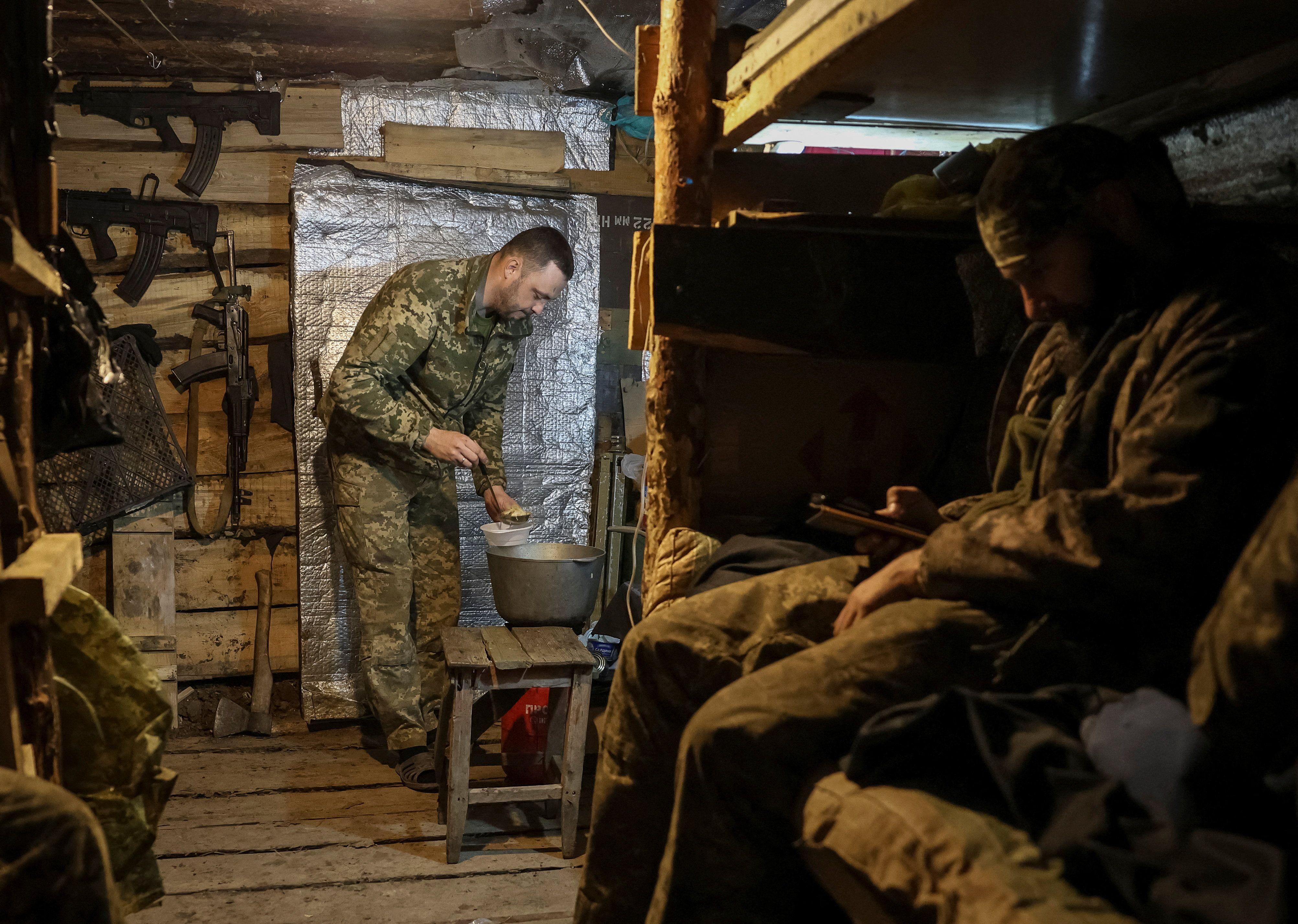 جندي من اللواء الآلي المنفصل الثلاثين التابع للقوات المسلحة الأوكرانية يُحضّر الطعام في مخبأ في موقع على خط المواجهة بالقرب من بلدة كراماتورسك في منطقة دونيتسك، أوكرانيا، 1 ديسمبر/كانون الأول 2025.